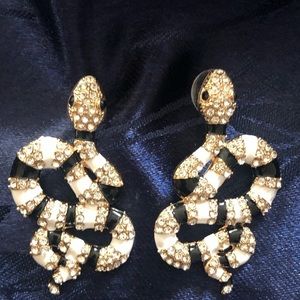 Serpentine shaped earrings with black and white enamel and sparkly stones
